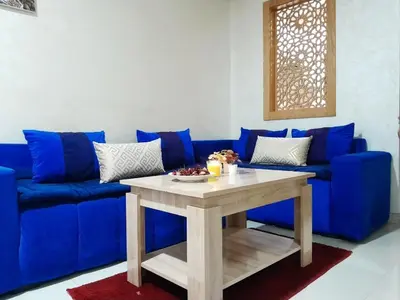 a blue couch with a table in a living room at Studio confortable au centre rabat agdal à côté du stade in Gare de Rabat-Aguedal