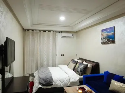 a small bedroom with a bed and a couch at Studio confortable au centre rabat agdal à côté du stade in Gare de Rabat-Aguedal