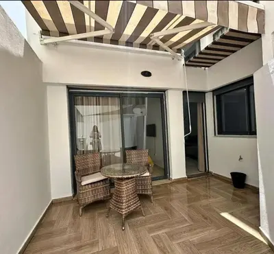 a patio with a table and wicker chairs at Apparemment errahma vile in Casablanca