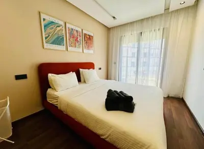 a bedroom with a bed with a black bag on it at Apparemment errahma vile in Casablanca