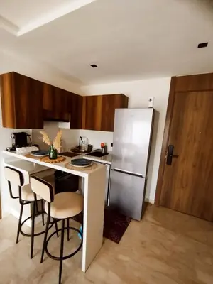 a kitchen with a refrigerator and some bar stools at New Cozy Studio In the Cornish of Casablanca in Casablanca
