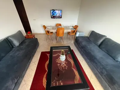 a living room with a couch and a dining room table at Appartement à 2 min gare Agdal bien situé in Rabat