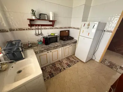 a kitchen with a white refrigerator and a sink at Appartement à 2 min gare Agdal bien situé in Rabat