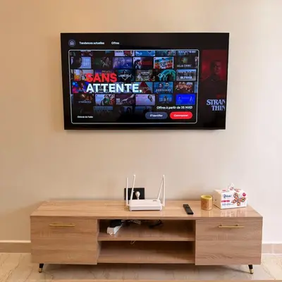 a television hanging on a wall with a wooden table at Cozy & Well-Equiped Studio - Valfleuri in Casablanca