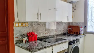 a kitchen with white cabinets and a counter top at Casablanca City Center Neoclassic Flat in Casablanca