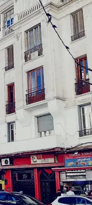 a tall white building with windows on a street at Casablanca City Center Neoclassic Flat in Casablanca