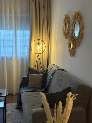 a living room with a couch and a mirror at The green stay in Rabat