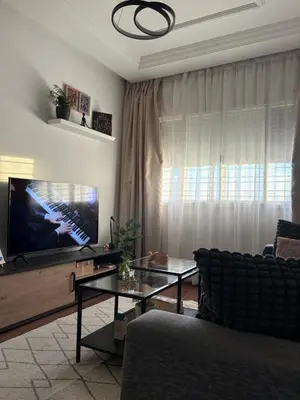 a living room with a tv and a couch and a table at The green stay in Rabat