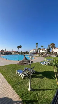 a group of lounge chairs and a light in a park at Spacious beach escape villa with pool & play areas in Mansouria