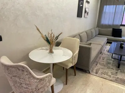 a living room with a table and a couch at Studio oasis calme et spacieux in Maarif