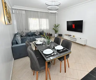 a living room with a table and a couch at Modern Luxury Apartment - Ground Floor in Rabat