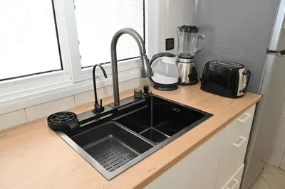 a kitchen counter with a sink and a blender at Modern Luxury Apartment - Ground Floor in Rabat