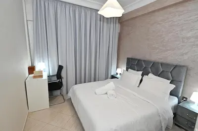 a bedroom with a large bed with white sheets at Modern Luxury Apartment - Ground Floor in Rabat