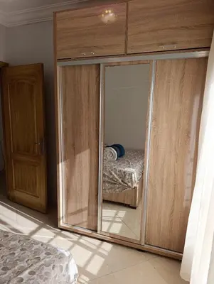 a bedroom with a glass cabinet with a bed in it at Carino Solare ben ordinato in Dar Ben Abdallah Ben Dehbi