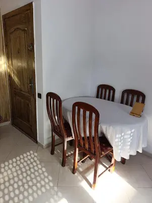 a table with four chairs and a white tablecloth on it at Carino Solare ben ordinato in Dar Ben Abdallah Ben Dehbi