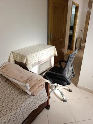 a bedroom with a bed and a chair and a desk at Carino Solare ben ordinato in Dar Ben Abdallah Ben Dehbi