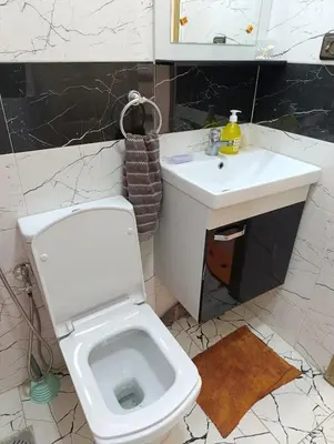 a bathroom with a white toilet and a sink at Carino Solare ben ordinato in Dar Ben Abdallah Ben Dehbi