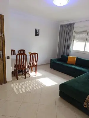 a living room with a couch and a table at Carino Solare ben ordinato in Dar Ben Abdallah Ben Dehbi