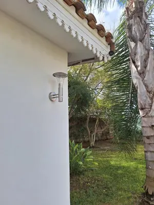 a door to a house with a security light on it at Chambre indépendante dans jardin calme avec vue mer Skhirat in Skhirat