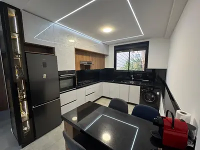 a kitchen with a black refrigerator and a sink at Appartement sur villa in Temara