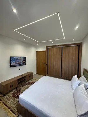 a bedroom with a large bed and a flat screen tv at Appartement sur villa in Temara