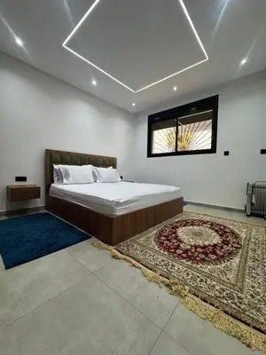 a bedroom with a bed and a window and a rug at Appartement sur villa in Temara