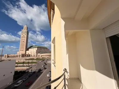 a view from a balcony of a building with a clock tower at Appartement avec vue sur monument emblématique Hassan II in Casablanca