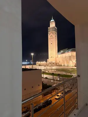 a large building with a clock tower at night at Appartement avec vue sur monument emblématique Hassan II in Casablanca