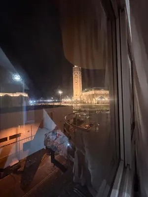 a view of a building from a window at night at Appartement avec vue sur monument emblématique Hassan II in Casablanca
