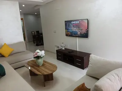 a living room with a couch and a table at Palm Pool View Apartment - Bouznika in Bouznika