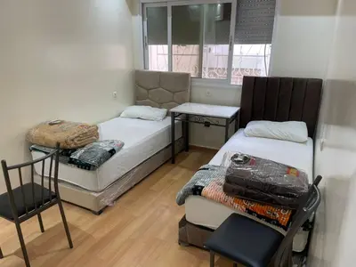 a small room with two beds and a chair at Casablanca Happy B&B in Casablanca