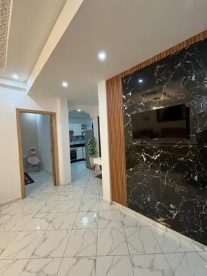 a living room with a stone wall with a flat screen tv at Charming appartement next to the airport in Deroua