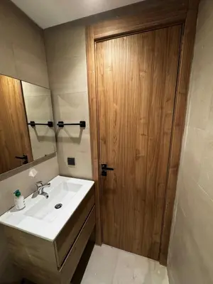 a bathroom with a sink and a wooden door at Studio 14 in Casablanca