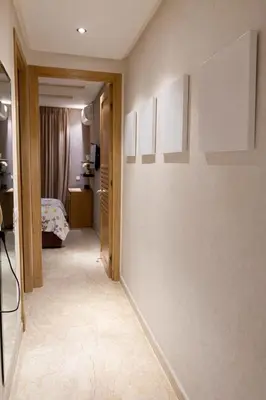 a hallway with a room with a bed and paintings on the wall at Chic Cozy Studio Maarif Casablanca in Casablanca