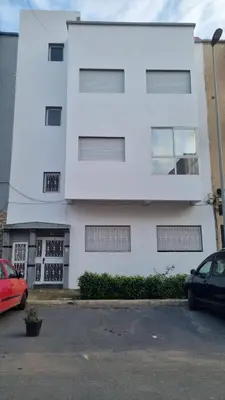 a white building with a car parked in front of it at Appartement moderne Temara à 10 minutes de Rabat in Temara