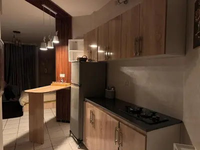 a kitchen with a refrigerator and a table in it at Fatine