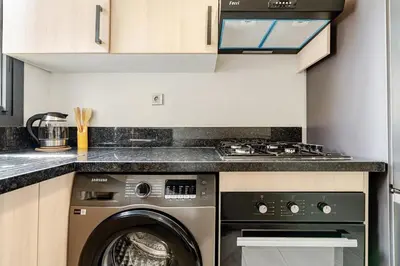 a kitchen with a washing machine and a stove at Appart luxeux à zenata piscine , plage à 3 min in Aïn Harrouda