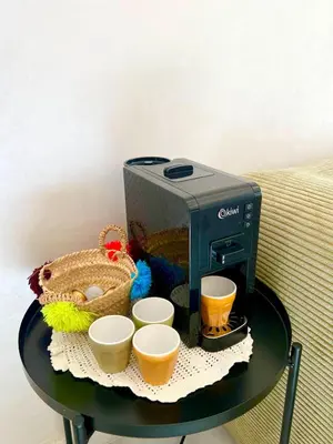 a table with a coffee maker and cups on it at Appart luxeux à zenata piscine , plage à 3 min in Aïn Harrouda