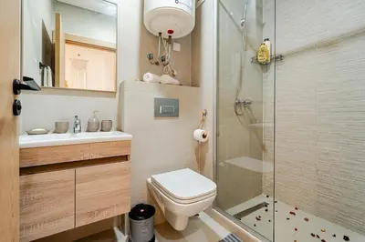 a bathroom with a toilet and a glass shower at Appart luxeux à zenata piscine , plage à 3 min in Aïn Harrouda