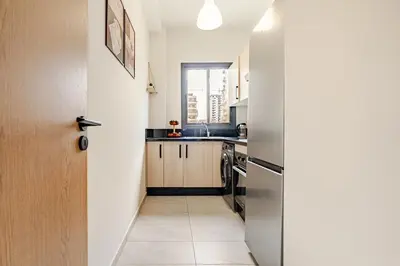 a kitchen with a stainless steel refrigerator and a sink at Appart luxeux à zenata piscine , plage à 3 min in Aïn Harrouda