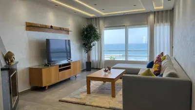 a living room with a couch and a flat screen tv at Apartment with impressive sea view! in Rabat