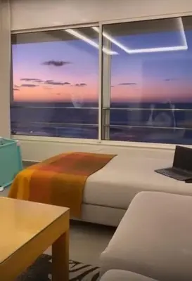 a bedroom with a bed and a window with a laptop at Apartment with impressive sea view! in Rabat