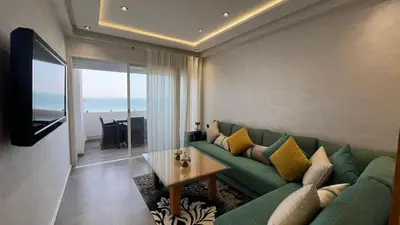 a living room with a green couch and a table at Apartment with impressive sea view! in Rabat