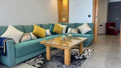 a living room with a blue couch and a coffee table at Apartment with impressive sea view! in Rabat