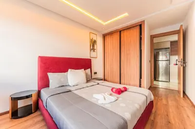 a bedroom with a large bed with a red headboard at L'osmo - 1 BR - 2m from CFC in Casablanca