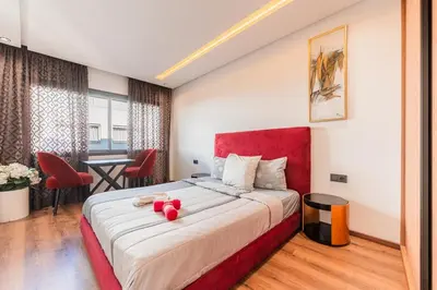 a bedroom with a large bed with a red headboard at L'osmo - 1 BR - 2m from CFC in Casablanca