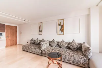 a living room with a couch and a table at L'osmo - 1 BR - 2m from CFC in Casablanca