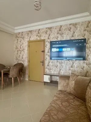 a living room with a couch and a television on the wall at Appartement lumineux a belvedere in Casablanca