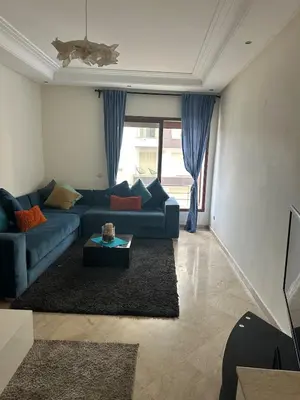 a living room with a blue couch and a table at Casablanca ANFA Apartment in Casablanca