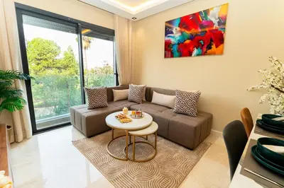 a living room with a couch and a table at Suite Cosy Moderne Chic Calme Jardin and Habous in Casablanca